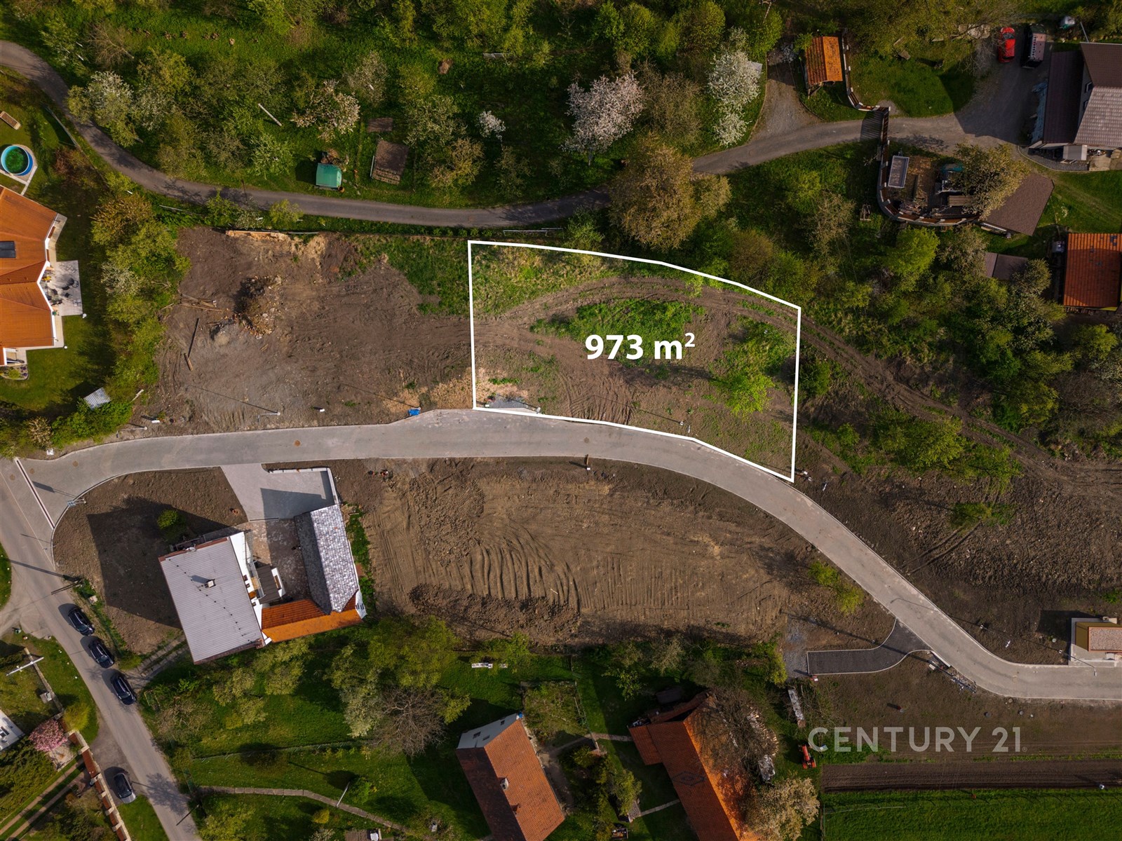 Prázdný stavební pozemek o rozloze 973 m² obklopený zelení, ideální pro výstavbu rodinného domu. Klidná lokalita s dostupností do centra.