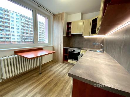 Moderní kuchyň s parketovou podlahou, vestavěným sporákem a velkými okny, poskytuje světlý prostor v rekonstruovaném bytě. | Pronájem bytu, 2+1, 56 m²