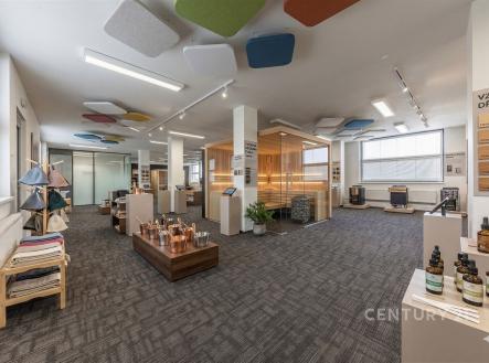 Velká komerční místnost s moderním kobercem, prosklenými příčkami a výraznými stropními panely nabízí světlý prostor vhodný pro kancelářské využití. | Pronájem - kanceláře, 152 m²