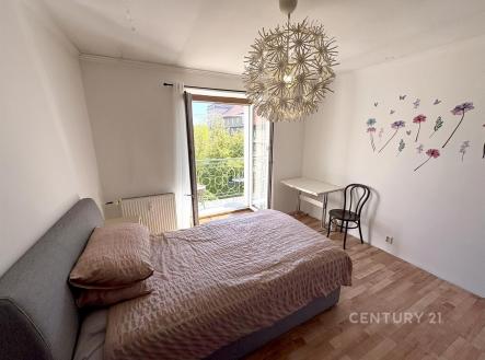 Světlá ložnice s parketovou podlahou, moderní dekorací a velkým oknem vedoucím na balkon, nabízí klidný prostor s výhledem na zeleň. | Prodej bytu, 2+1, 59 m²