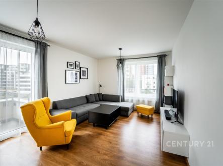 Světlý obývací pokoj s parketovou podlahou, velká okna, moderní design, pohodlná sedací souprava, žluté křeslo pro kontrast. | Prodej bytu, 3+kk, 86 m²