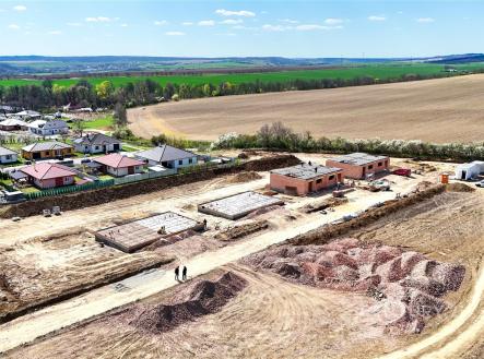 Staveniště rodinných domů na venkově, rozestavěné budovy a stavební pozemek, výhled na pole a zelené okolí, ideální pro bydlení v přírodě. | Prodej - dům/vila, 120 m²