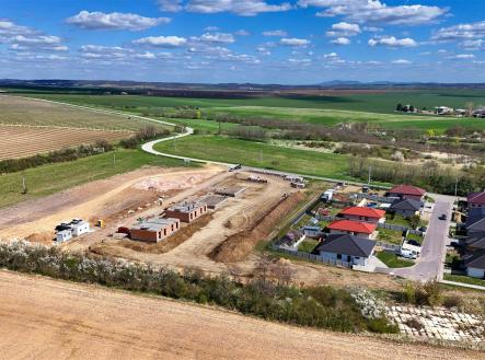 Rozestavěná obytná oblast, moderní domy s červenými střechami, okolní přírodní krajina, nedokončená stavba rodinných domů, klidná lokalita | Prodej - dům/vila, 120 m²