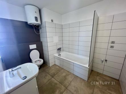 Koupelna s moderními dlaždicemi, vanou a světlým obkladem. Kombinace tmavých a světlých tónů vytváří elegantní atmosféru. | Pronájem bytu, 3+1, 73 m²