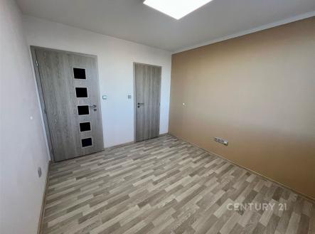 Prázdný pokoj s dřevěnou podlahou, moderními dveřmi a světlými stěnami, ideální pro personalizaci a zařízení dle vlastního vkusu. | Pronájem bytu, 3+1, 73 m²