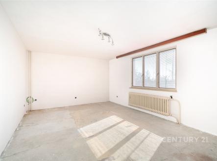 Světlý obývací pokoj s velkými okny, betonovou podlahou a moderním vytápěním, ideální pro rekonstrukci podle vlastních představ. | Prodej - dům/vila, 133 m²