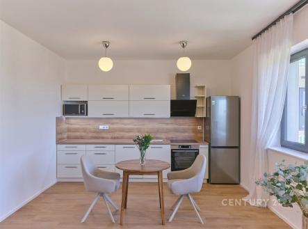 Moderní kuchyň s dřevěnou podlahou, světlým nábytkem a velkými okny, elegantní povrchová úprava, prostorný design, vynikající světelnost. | Prodej bytu, 1+kk, 39 m²