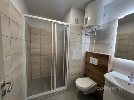 Moderní koupelna s dlažbou, sprchovým koutem a závěsnou toaletou, světlé obklady a elektrický bojler, vynikající stav. | Pronájem bytu, 1+1, 37 m²