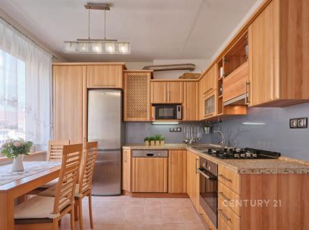 Moderní kuchyň s dřevěnou linkou, dlažbou na podlaze a vestavěnými spotřebiči, prostorná a světlá díky velkým oknům. | Prodej bytu, 3+1, 76 m²