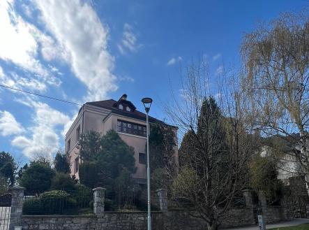 Vila s kamenným plotem, zasazená v udržované zahradě, nabízí klidné prostředí. Tradiční styl s moderními prvky, ideální pro prostorné bydlení. | Pronájem bytu, garsoniéra, 30 m²