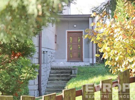 Vstup do rodinného domu s dřevěnými dveřmi, obklopen zelení, cihlový obklad domu, klidná lokalita, přírodní prostředí | Pronájem bytu, 2+1, 67 m²
