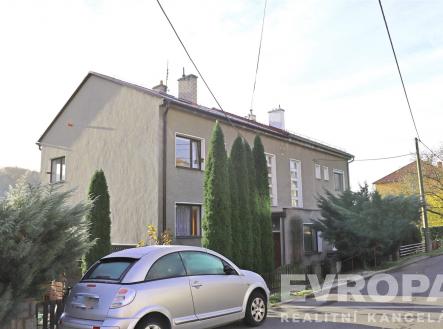 Šedý řadový dům s velkými okny a upravenou předzahrádkou se vzrostlými stromy, nachází se v klidné rezidenční čtvrti. | Pronájem bytu, 2+1, 67 m²
