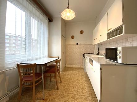 kuchyně s mikrovlnná trouba, bílé skříně, závěsné osvětlení, a přirozené světlo | Prodej bytu, 2+1, 53 m²