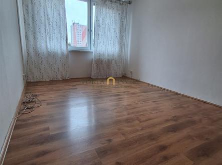 Prostorná ložnice s parketovou podlahou, velkým oknem a moderní výzdobou, ideální pro světlý a útulný interiér. | Prodej bytu, 2+kk, 45 m²