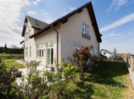 Exteriér rodinného domu s moderní fasádou, zahrada s terasou a upraveným trávníkem, prostorný pozemek, klidná lokalita. | Prodej - dům/vila, 249 m²