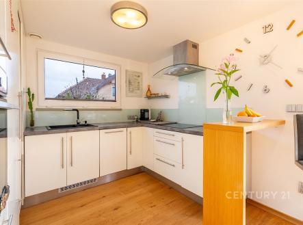 Moderní kuchyň s parketovou podlahou, světlý interiér, velká okna, moderní vybavení, dřevěné prvky, vestavěné spotřebiče, elegantní design. | Prodej - dům/vila, 115 m²