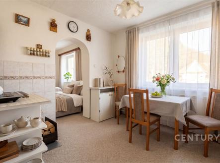 Jídelní kout s dřevěným nábytkem, velká okna, světlý interiér, keramická dlažba, útulný styl, rekreační dům v klidné lokalitě. | Prodej - dům/vila, 93 m²