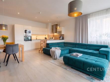Moderní obývací pokoj s parketovou podlahou, velká okna prosvětlují prostor a stylový nábytek dodává místnosti elegantní vzhled. | Prodej bytu, 3+kk, 88 m²