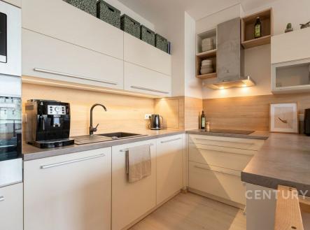 Moderní kuchyň s vestavěnými spotřebiči, světlou dřevěnou linkou a parketovou podlahou, ideální pro stylové bydlení. | Prodej bytu, 3+kk, 88 m²