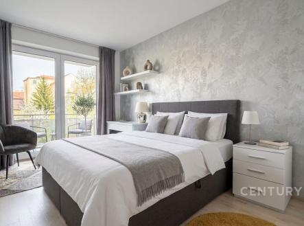 Prostorná ložnice s moderní tapetou, velká okna s balkonem, parketová podlaha a stylové dekorace vytvářejí světlý a útulný prostor | Prodej bytu, 3+kk, 88 m²