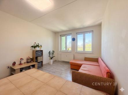 Světlý obývací pokoj s velkými okny, moderní podlahou a rekultivovaným interiérem, nabízí komfort a styl pro bydlení. | Prodej bytu, 1+kk, 31 m²