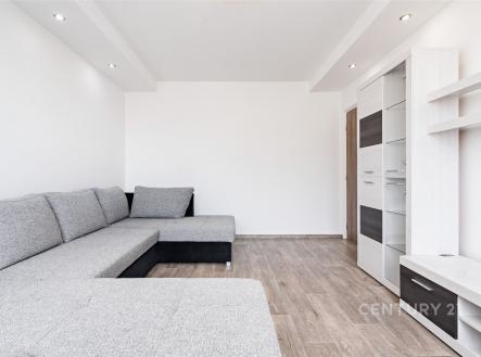 Světlý obývací pokoj s moderní sedací soupravou, laminátovou podlahou a vestavěnými policemi, minimalistický design a elegantní osvětlení. | Pronájem bytu, 2+1, 52 m²