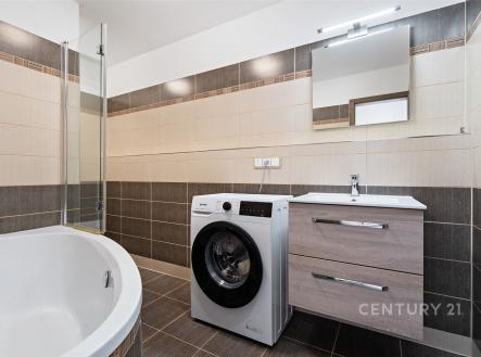 Moderní koupelna s tmavou dlažbou, prostornou vanou a moderní pračkou, elegantní umyvadlová skříňka, světlé obklady na stěnách | Pronájem bytu, 2+1, 52 m²