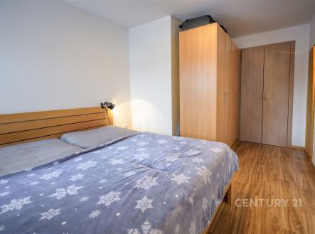 Prostorná ložnice s parketovou podlahou, vestavěná skříň a moderní design interiéru. | Prodej - dům/vila, 180 m²