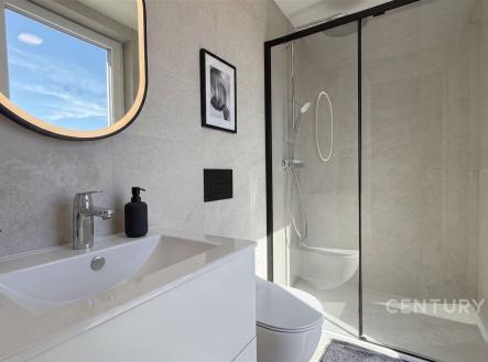 Moderní koupelna s velkou sprchou, světlé dlaždice a elegantní zrcadlo, minimalistický design přináší svěžest a styl. | Prodej - dům/vila, 111 m²