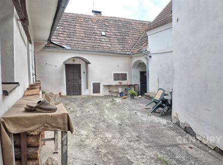 Venkovní dvůr s betonovou podlahou, částečně zastřešený, s rustikálními prvky a zahradním nábytkem, vhodný k rekonstrukci. | Prodej - dům/vila, 160 m²