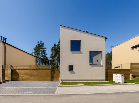 Moderní rodinný dům s minimalistickou fasádou, velkými okny a dřevěným plotem, nachází se v klidné vilové čtvrti. | Prodej - dům/vila, 119 m²