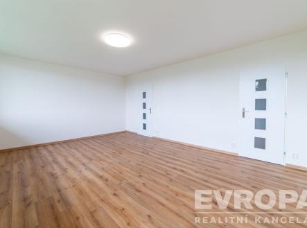 Světlý obývací pokoj s parketovou podlahou, moderní dveře a minimalistický styl, prostorný interiér vhodný k osobnímu uspůsobení. | Pronájem bytu, 3+1, 74 m²