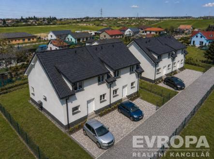 Řadové rodinné domy s moderní fasádou a parketovými příjezdovými cestami, obklopené zelení a nacházející se v klidné oblasti. | Prodej - dům/vila, 119 m²