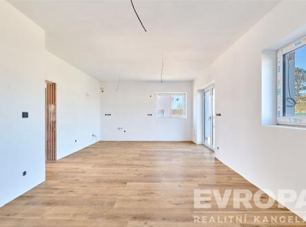 Světlý obývací pokoj s parketovou podlahou, velkými okny a moderním stylem, ideální pro rodinné bydlení. | Prodej - dům/vila, 119 m²