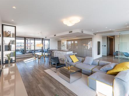 Světlý obývací pokoj s moderní parketovou podlahou, velkými okny a elegantním nábytkem. Otevřený prostor propojený s kuchyní nabízí komfortní bydlení. | Prodej bytu, 4+kk, 196 m²