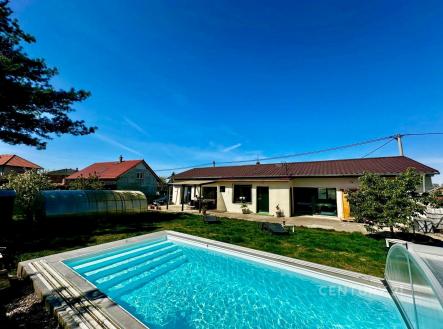 Zahrada s bazénem u moderního domu, terasa s velkými okny, udržovaná zeleň, ideální pro rodiny hledající klidný a komfortní životní styl. | Prodej - dům/vila, 135 m²