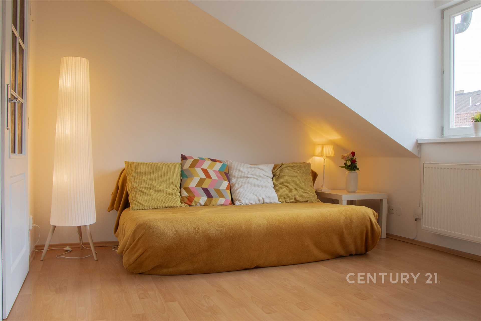 Podkrovní pokoj s parketovou podlahou, velká okna zajišťují světlé a útulné prostředí, minimalistický design s moderním vybavením.