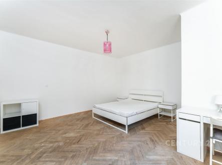 Prostorná ložnice s parketovou podlahou, minimalistickým nábytkem a světlou výmalbou, nabízí moderní a čistý design. | Prodej bytu, 2+1, 70 m²