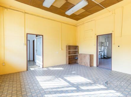 Světlý pokoj s dlažbou, velkými okny a vestavěnými skříněmi, ideální pro rekonstrukci nebo modernizaci v bytovém domě. | Pronájem - obchodní prostor, 64 m²