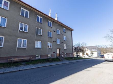 Čtyřpatrový bytový dům s šedou fasádou a bílými rámy oken v klidné ulici, vhodný pro investice nebo bydlení s výhledem na městské prostředí. | bytu, 3+1, 59 m²
