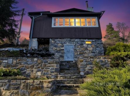 Chata s kamennou fasádou, velkými okny a zahradou, podvečerní atmosféra, klidná lokalita v přírodě. | Prodej - chata/rekreační objekt, 39 m²