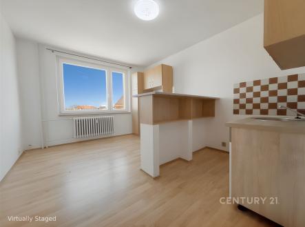 Světlá kuchyň s parketovou podlahou a vestavěnými skříněmi nabízí moderní design a velká okna zajišťují dostatek přirozeného světla. | Prodej bytu, 1+kk, 20 m²