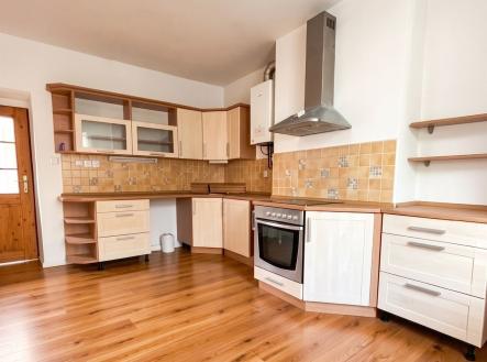 Kuchyň s parketovou podlahou a dřevěnými skříňkami, moderní spotřebiče a obklady stěn, světlý prostor s velkými okny. | Pronájem bytu, 3+kk, 72 m²