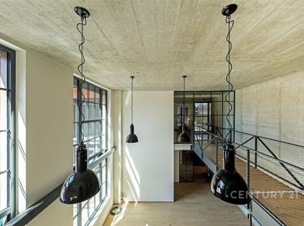 Industriální obývací pokoj s betonovým stropem, velkými okny a dřevěnou podlahou, moderní loft styl a kovové zábradlí. | Prodej - kanceláře, 181 m²