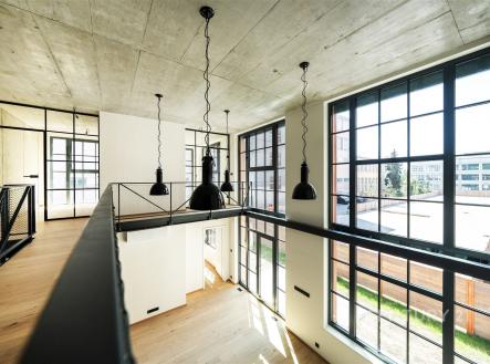 Mezonet s velkými okny, moderním designem a dřevěnou podlahou, nabízí světlý prostor s výhledem, kovovými prvky a vysokými stropy. | Prodej - kanceláře, 181 m²