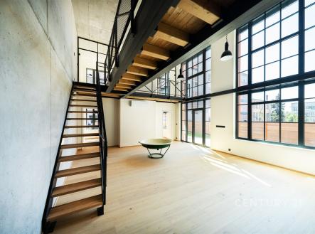 Prostorný obývací pokoj s velkými okny a dřevěnou podlahou nabízí moderní styl a industriální design. | Prodej - kanceláře, 181 m²