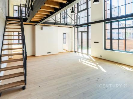Světlý obývací pokoj s moderními velkými okny, parketovou podlahou a stylovým kovovým schodištěm, ideální pro vzdušný interiér. | Prodej - kanceláře, 181 m²