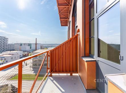 Moderní balkón s ocelovým zábradlím, nabízí výhled na městskou krajinu. Světlý prostor s moderním designem a slunečním světlem. | Prodej bytu, 3+kk, 66 m²