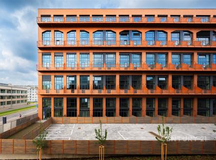 Průmyslová budova s moderními prvky, velkými okny a rekonstrukcí fasády, zpevněná plocha před budovou, ideální pro komerční využití | Prodej bytu, 2+kk, 49 m²