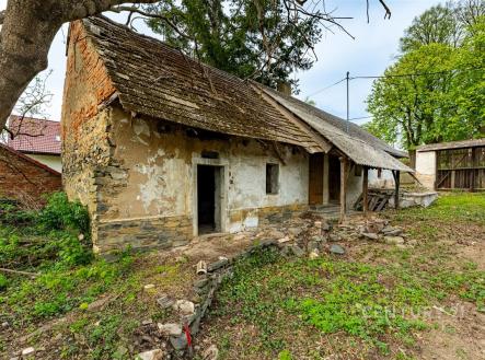 Starý venkovský dům s kamennou fasádou, dřevěnou střechou a potřebou rekonstrukce, nachází se na prostorném pozemku obklopeném zelení. | Prodej - zemědělský objekt, 3 279 m²